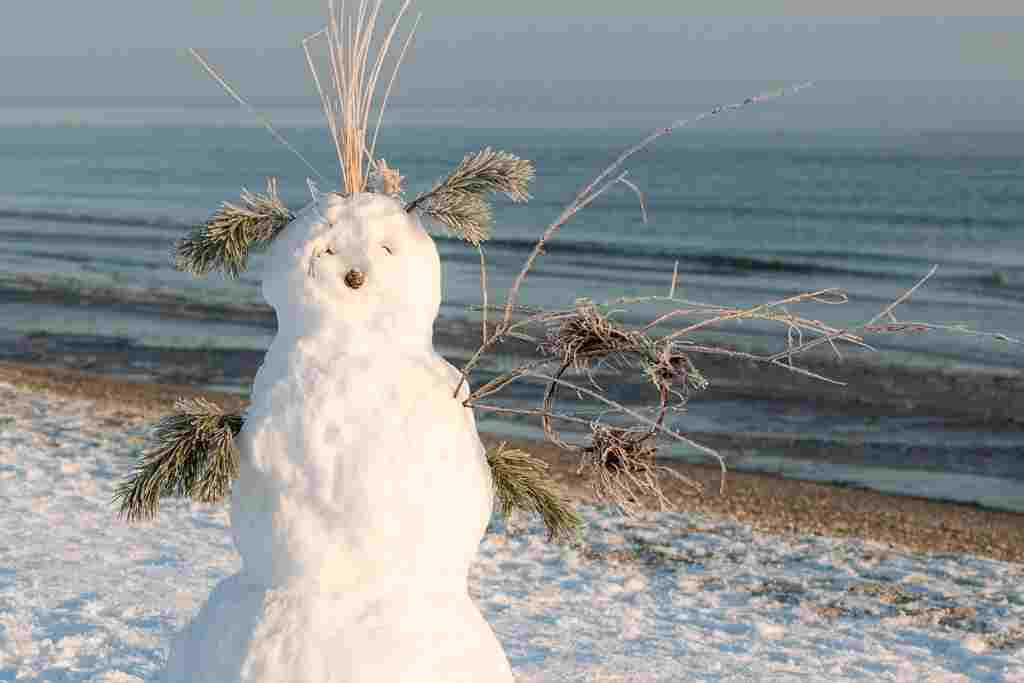 A snowman standing behind a body of water. I am the snowman!
